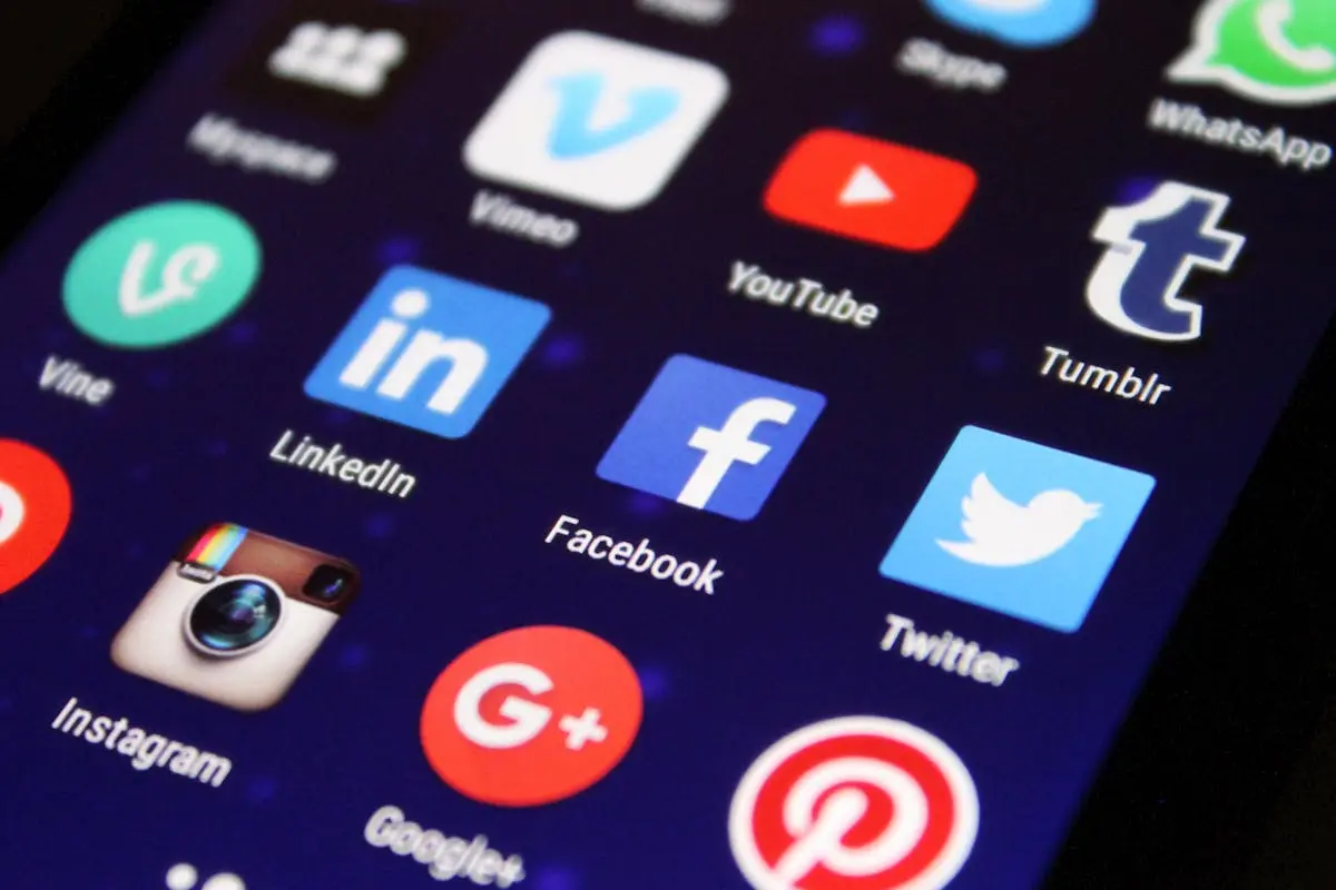 Close-up of a smartphone screen showing various social media app icons such as Facebook and Twitter.